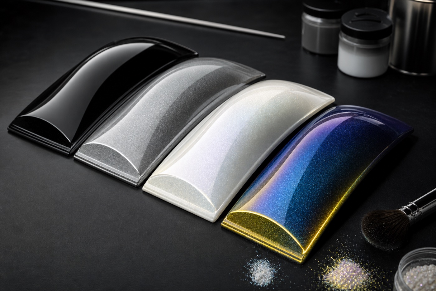 Four automotive coating samples showing solid, metallic, pearl white and blue-gold colour shifting finishes